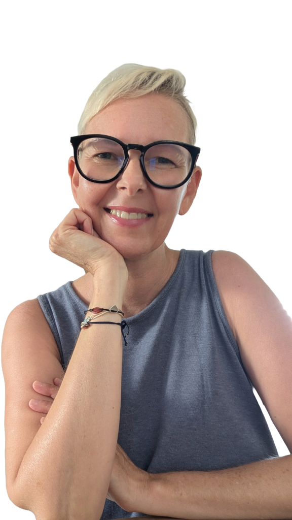 Disability Writer, Lia Stoll, a light-skinned woman with short blond hair, is wearing dark-framed glasses, a blue t-shirt.